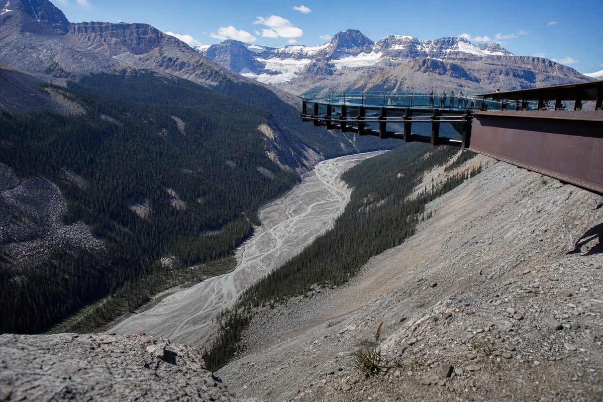 The glass-floored Glacier Skywalk curving out over the Sunwapta Valley, with snow-streaked peaks behind