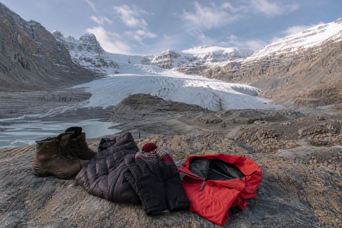 Warmly dressed visitors in layers and sturdy boots standing on the Athabasca Glacier at the Columbia Icefield